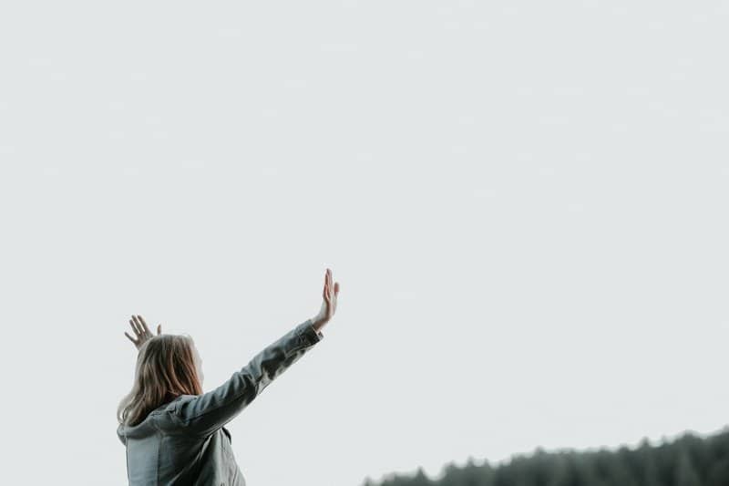 Woman with arms raised to heaven