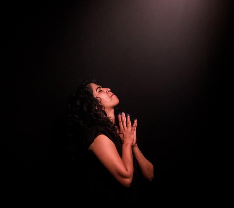 Woman praying in the dark